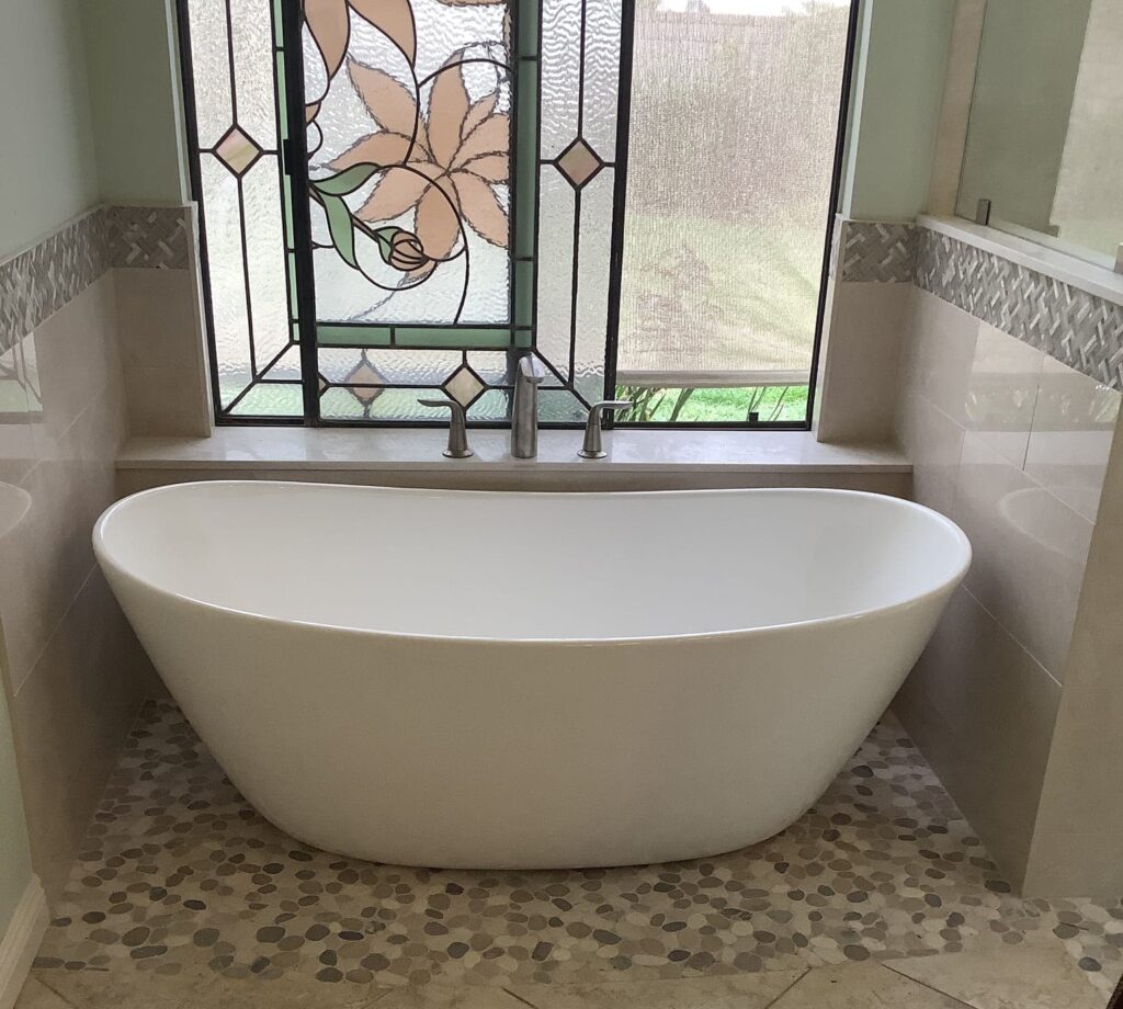 Modern soaking bathtub in a bright upscale bathroom with natural light and clean finishes